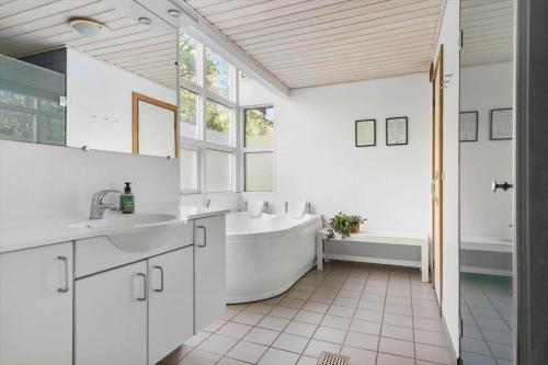 a white bathroom with a tub and a sink at 6715-Hasle-Skovkanten-12 in Hasle