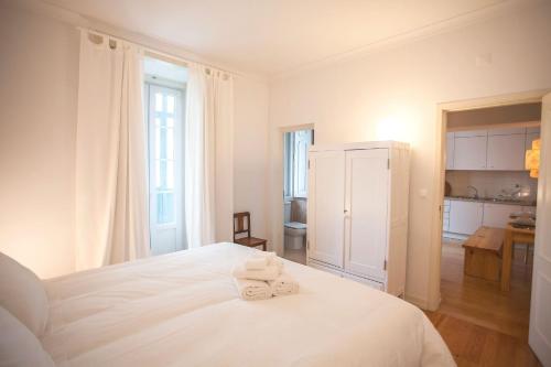リスボンにあるLovelyStay - Elegance and Charm!の白いベッドルーム(ベッドにタオル2枚付)