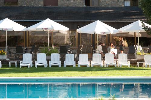 a group of chairs and umbrellas next to a pool at Hotel Florido in Sort