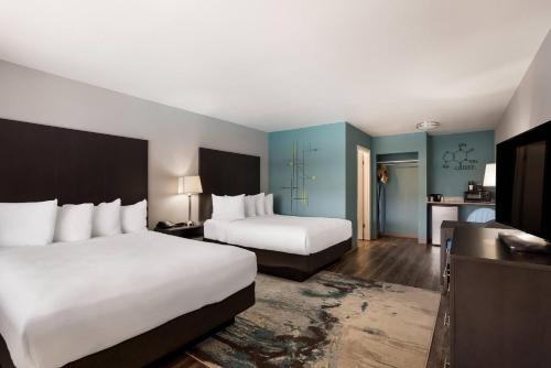 a hotel room with two beds and blue walls at Richland Riverfront Hotel, an Ascend Collection Hotel in Richland