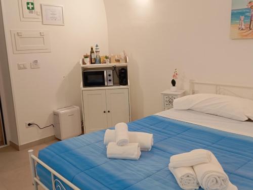a bedroom with a bed with towels on it at Ranieri rooms & relax Mare in Mola di Bari