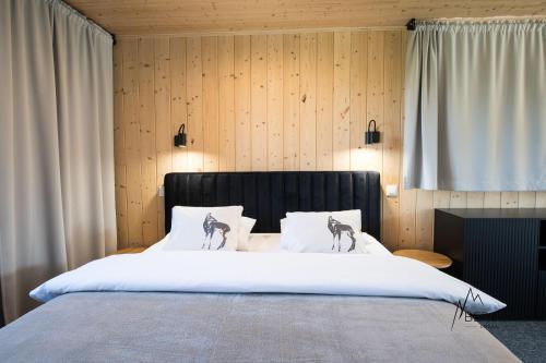 a bedroom with a large bed with white sheets at Chata Bergen in Vysoké Tatry