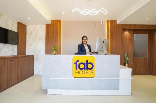 a woman standing at a reception desk in a hotel lobby at FabHotel Sahyadri Mantram in Pune
