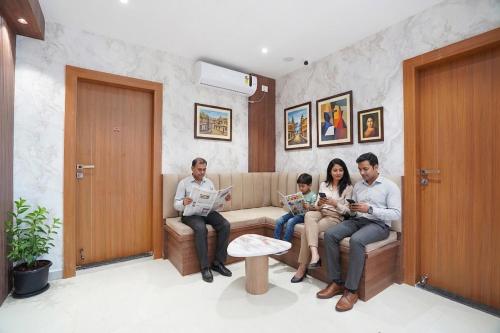 a family sitting on a couch in a living room at FabHotel Sahyadri Mantram in Pune