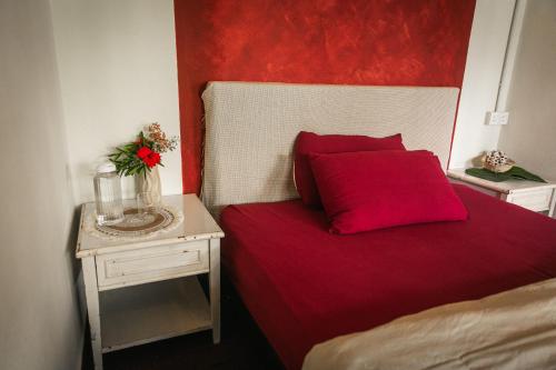 a bedroom with a red bed with a table with a red headboard at Liv Bumi Oasis in Pantai Cenang