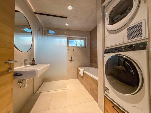 a bathroom with a washing machine and a sink at Mid Mountain Apartment Tirol in Wiesing