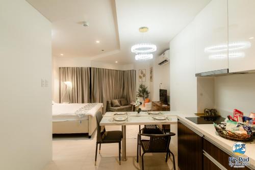 a kitchen and a bedroom with a bed and a table at Tambuli Seaside Living Pad seaview in Maribago
