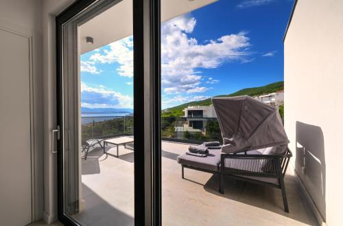 a balcony with a chair and a view of the ocean at Luxurious Sea-view 3BR Apartment with Private Pool-Villa Quadris-Crikvenica in Crikvenica