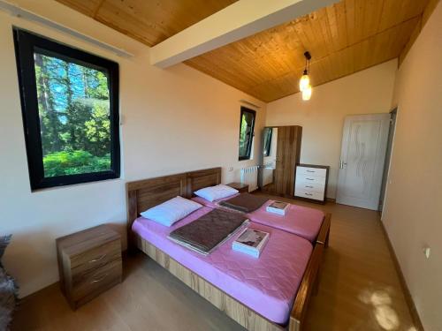 a bedroom with a large pink bed in a room at Park & Sea Townhouse in Makhinjauri