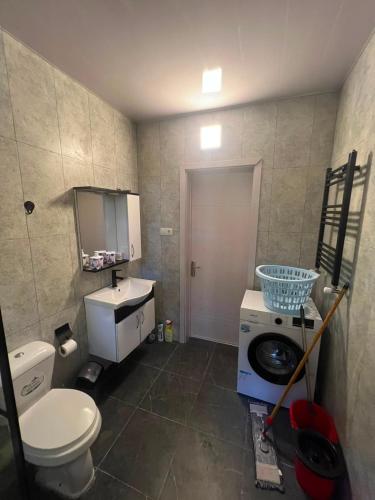 a bathroom with a toilet a sink and a washing machine at Park & Sea Townhouse in Makhinjauri