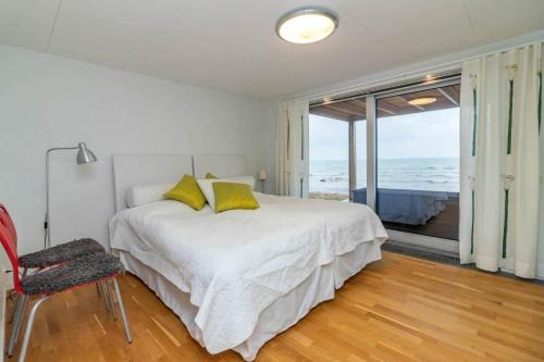 a white bedroom with a bed with yellow pillows at VGO1064-Karlsborg-Silverdalen-1 in Karlsborg