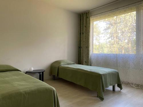 a bedroom with two beds and a window at Just home in Hamina