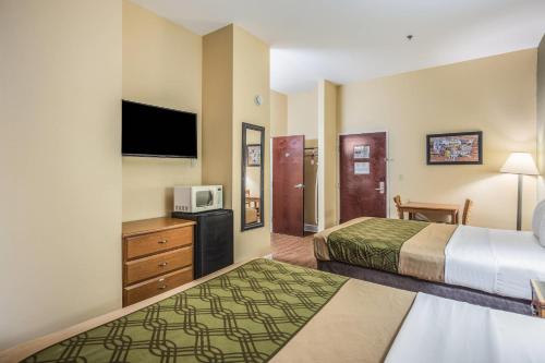 a hotel room with two beds and a tv at Econo Lodge Valdosta Mall Area in Valdosta