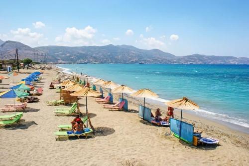 a beach with umbrellas and people sitting on the sand at Apartment Simply 101 in Gázion