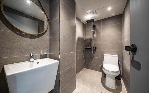 a bathroom with a toilet and a sink and a mirror at Lime Hotel in Busan