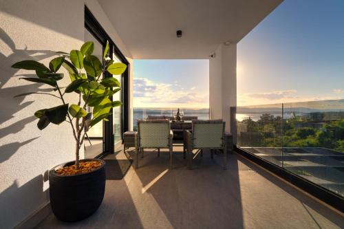 a dining room with a table and a potted plant at Luxurious Sea-view 3BR Apartment with Private Pool-Villa Quadris-Crikvenica in Crikvenica