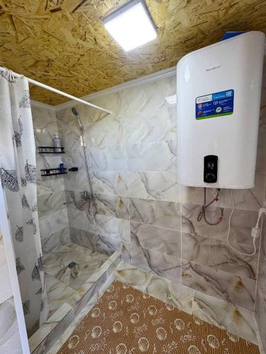 a bathroom with a shower with a water heater at Sky yurt camp in Këk-Say