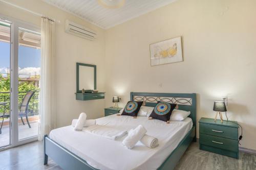 a bedroom with a large bed and a balcony at Odysseia Beachside Apartments in Nikiana