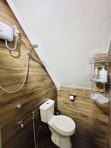 a bathroom with a toilet and a shower at Nica's Palace Baguio in Baguio