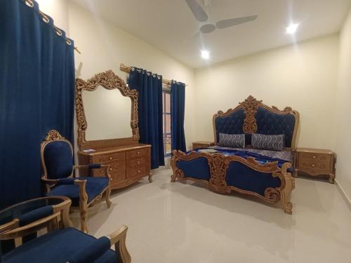 a bedroom with a blue bed and a mirror at ROYAL VILLA Bhurban in Murree