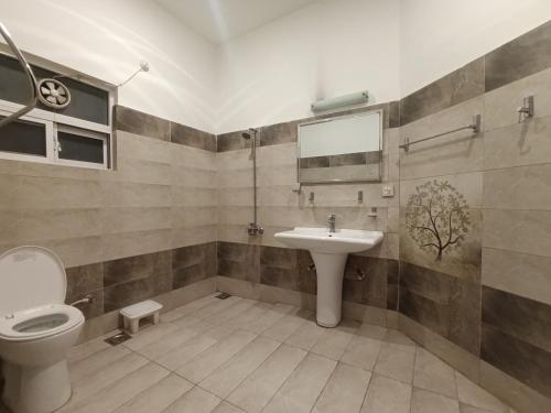 a bathroom with a toilet and a sink at ROYAL VILLA Bhurban in Murree