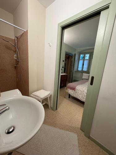 a bathroom with a sink and a bedroom with a bed at Villa Monica in Brentonico