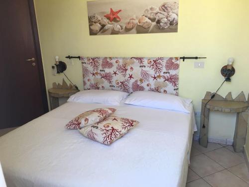 ein Schlafzimmer mit einem Bett mit zwei Kissen darauf in der Unterkunft Appartamenti La Risacca in Lampedusa