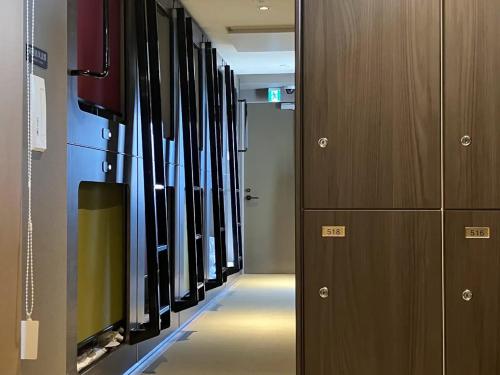 a hallway with a row ofillanceillanceillanceillanceillanceillanceillancefficient at Capsule Hotel Suzumoriya in Tokyo