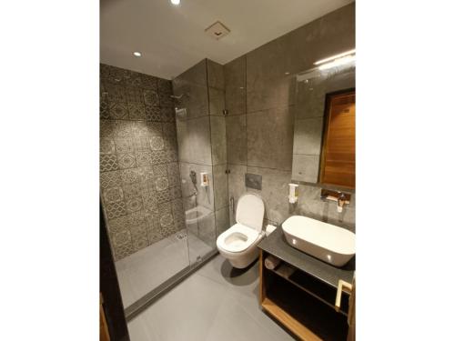 a bathroom with a toilet and a sink and a shower at La Casa De Landour in Mussoorie
