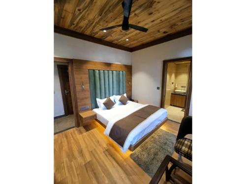 a bedroom with a large bed and wooden ceilings at La Casa De Landour in Mussoorie