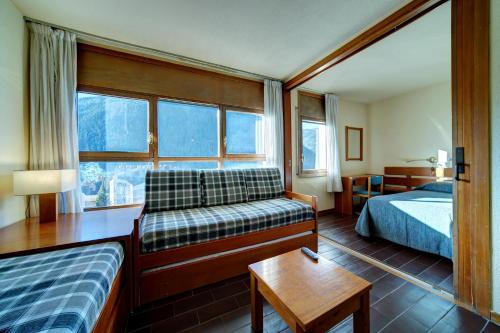 a hotel room with a bed and a couch at Apartamentos MultiBaqueira in Baqueira-Beret