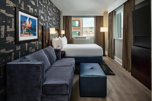 a hotel room with a bed and a couch at Hotel Alex Johnson Rapid City, Curio Collection by Hilton in Rapid City