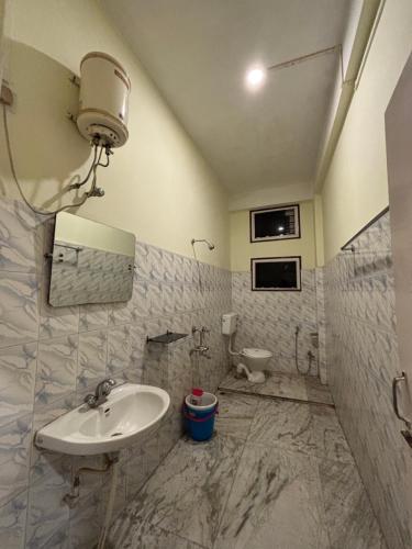 a bathroom with a sink and a toilet at Hotel Nikita in Jorhat