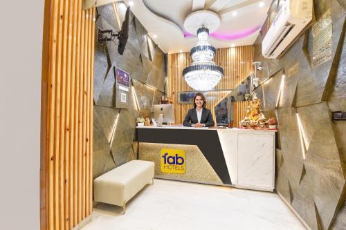 a woman sitting at a reception desk in a restaurant at FabHotel Dev Palace II - Nr Ashok Vihar in New Delhi