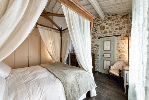 a bedroom with a bed and a stone wall at Drogheria e Locanda Franci in Montalcino
