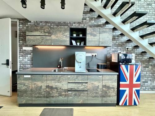 a kitchen with a sink and a brick wall at Maritime Suite #Full Seaview with sunrise #Pool Table #Water filter machine #Georgetown #6pax duplex unit #Private host in Jelutong