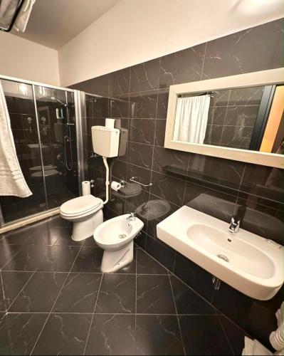 a bathroom with two toilets and a sink and a shower at Hotel San Carlo in Cesenatico