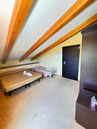 a room with a bed and a bench and a door at Hotel San Carlo in Cesenatico