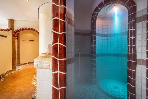 a bathroom with a shower with a large blue tub at Gasthof Kogelalm in Wagrain
