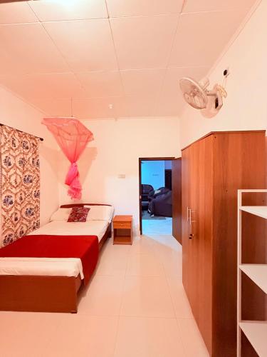 a bedroom with a bed with a red blanket at Thalpe Gedara Villa in Talpe