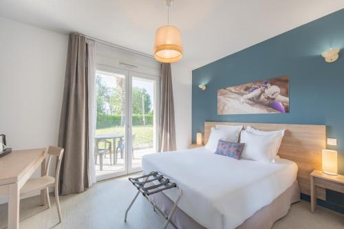 a bedroom with a bed and a desk and a window at Comfort Aparthotel Cannes Mandelieu in Mandelieu-La Napoule