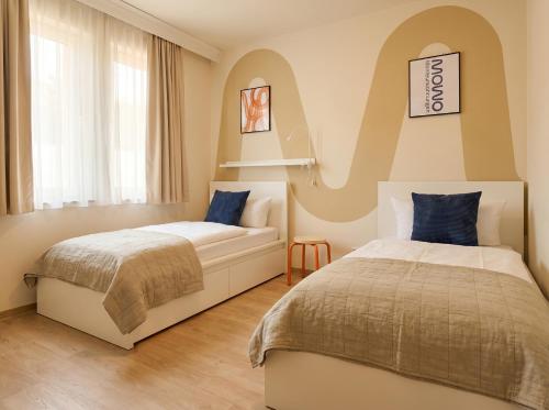 a bedroom with two beds and a couch at MOWO Kornwestheim in Kornwestheim