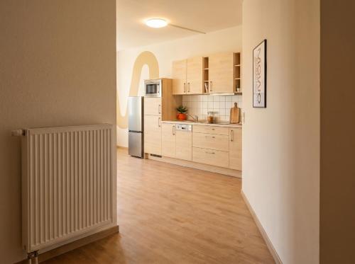 a kitchen with wooden floors and a refrigerator at MOWO Kornwestheim in Kornwestheim