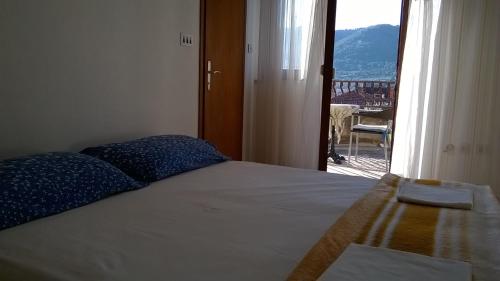 a bedroom with a bed with a view of a balcony at Studio Rade in Stari Grad
