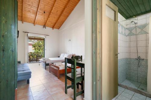 a bathroom with a shower and a living room at Lenia Studios in Kalamitsi