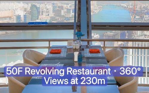 a table and chairs in front of a large window at Novotel Atlantis Shanghai in Shanghai