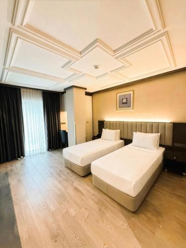 a hotel room with two beds and a coffered ceiling at Residence Hotel By Ketenci in İzmir
