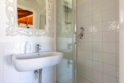 a bathroom with a sink and a mirror and a shower at Villa Glory piscina privata in Cuile Pazzoni