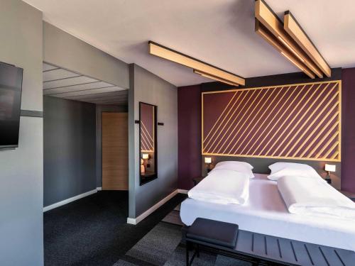 ein Hotelzimmer mit Bett und Fernseher in der Unterkunft B&B Hotel Aschaffenburg in Aschaffenburg