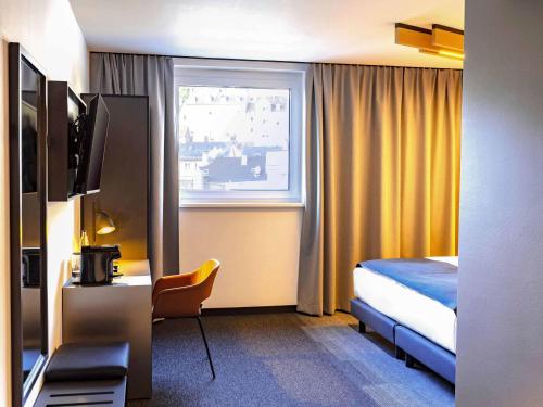 ein Hotelzimmer mit einem Bett und einem Fenster in der Unterkunft B&B Hotel Aschaffenburg in Aschaffenburg